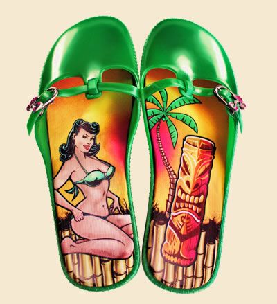 two green sandals with a vintage pinup girl on one and a tiki and palm tree on the other.