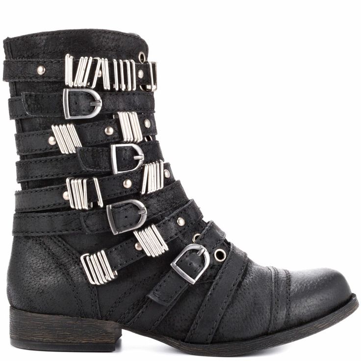 a black leather ankle boot with multiple straps and silver buckles is shown in a studio shot. the boot has a round toe and a stacked heel. the straps are arranged horizontally around the ankle and calf, with silver buckles and hardware. the boot is in a punk or motorcycle style.
