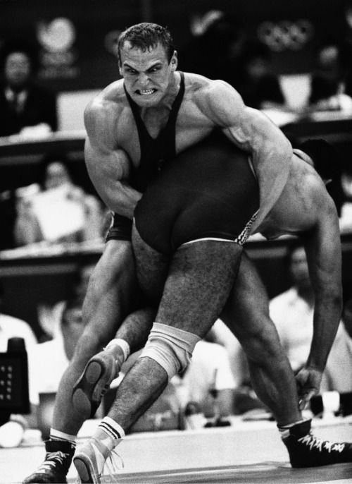 two wrestlers grapple on the mat during a wrestling match. the wrestler in the foreground is attempting to take down his opponent, who is trying to defend himself. both wrestlers are strong and athletic, and the match is close and intense. the image captures the power and determination of these athletes as they compete for victory.
