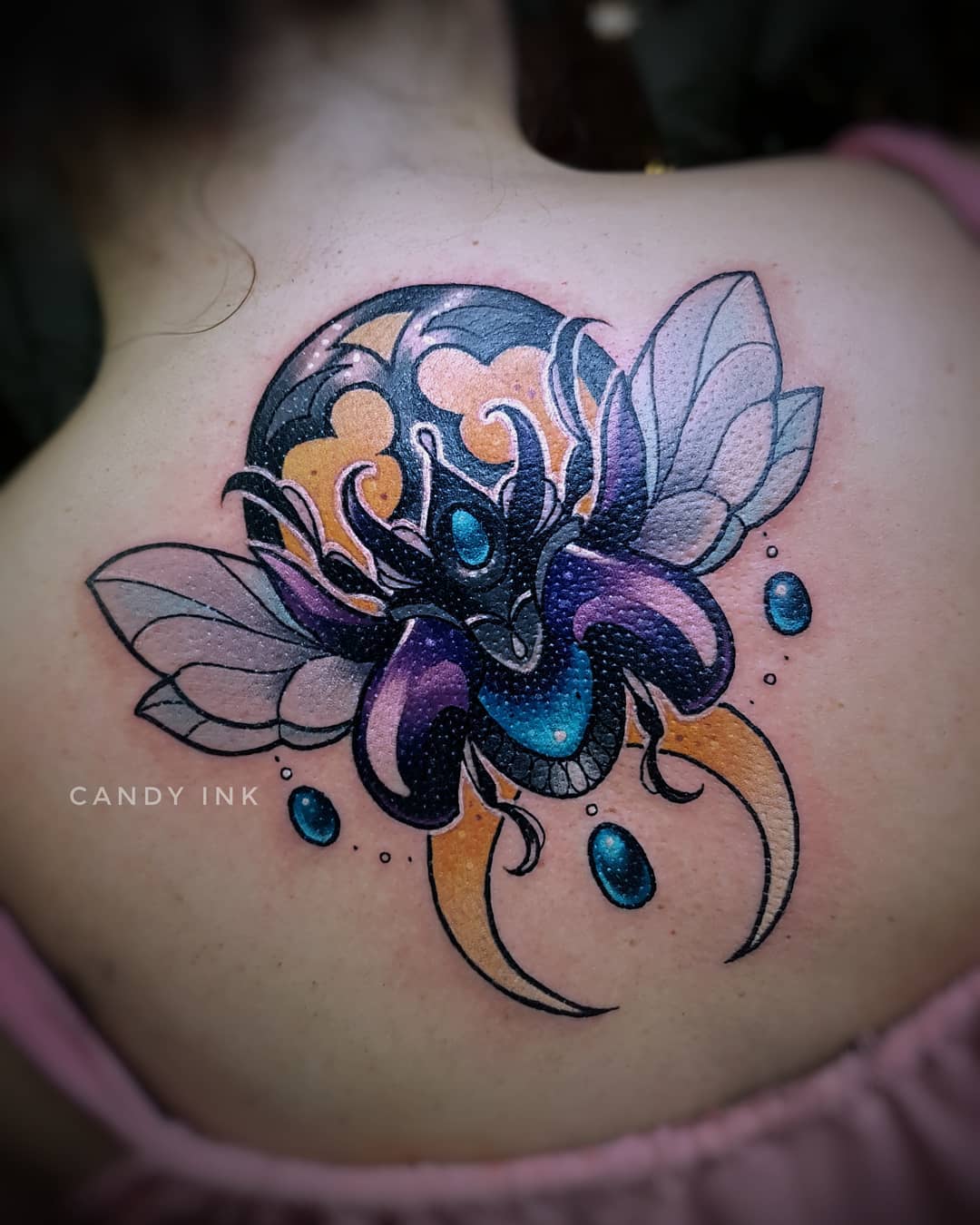 a neo traditional tattoo of a beetle with jewels on its back and wings. the beetle is on a crescent moon.