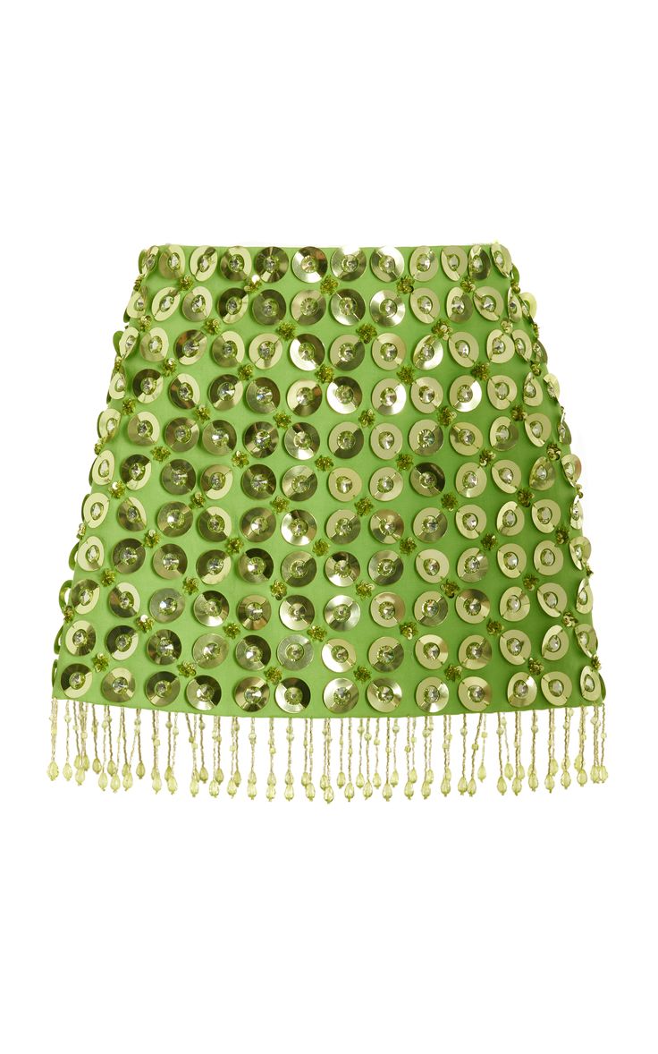 a green mini skirt with sequin embellishments and a beaded fringe. the skirt is made of a shiny fabric and has a high waist. the skirt is perfect for a party or club night out.