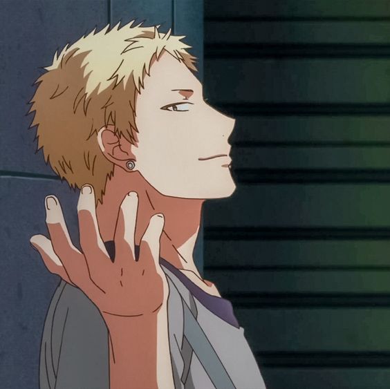 a sideview portrait of an anime man with short blonde hair and a goatee.  he has an earring in his left ear and is wearing a grey jacket and dark purple shirt. he is leaning against a dark wall with his right hand raised, palm facing the viewer. the background is dark and blurry with warm light coming from the left side of the image, illuminating the man's face and hand.
