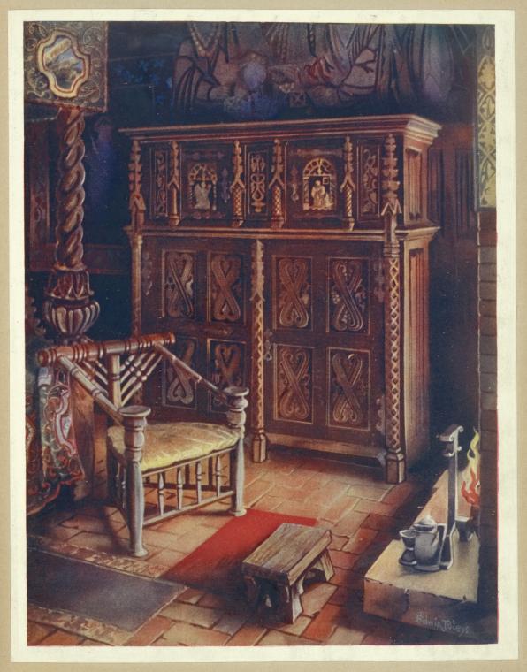 the image shows an interior scene featuring a wooden chair, a large ornately carved wooden cabinet, a small wooden stool, and a fireplace. the room has a brick floor with a small red rug placed in front of the chair. a tapestry and a painting adorn the walls, adding to the overall decorative and religious feel of the space. the cabinet is intricately carved, and the fireplace has pottery pieces on it.