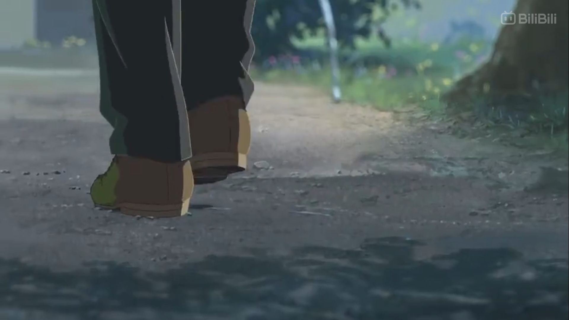 the image shows a person walking away from the viewer down a dirt path. the person is wearing brown shoes and dark pants. the path is surrounded by grass and trees, and the lighting suggests an overcast day. the overall atmosphere is peaceful and serene.