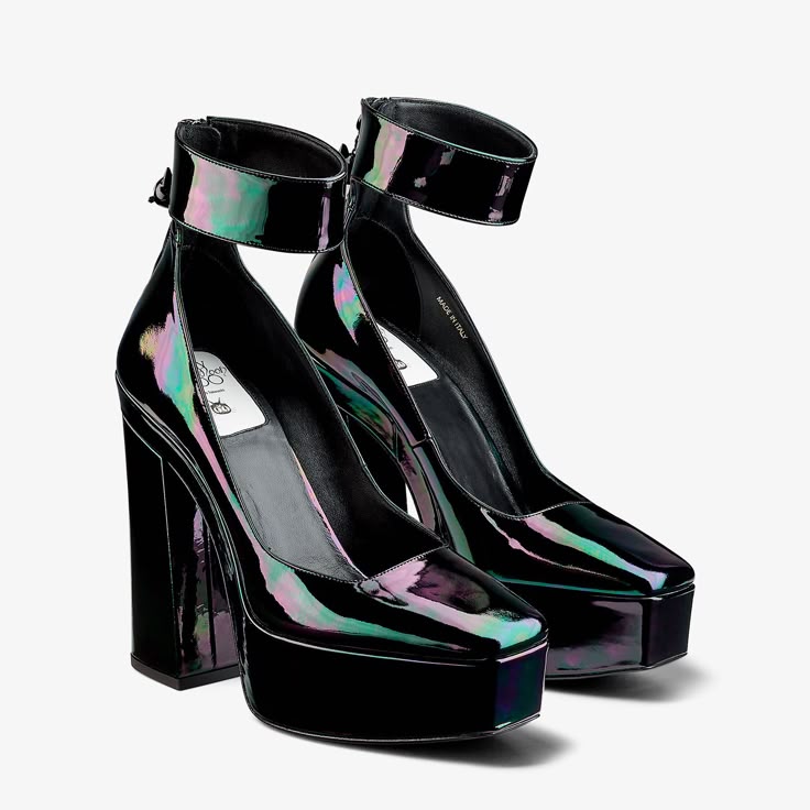 two black, iridescent platform heels with ankle straps are arranged on a white background. the heels are made of patent leather.