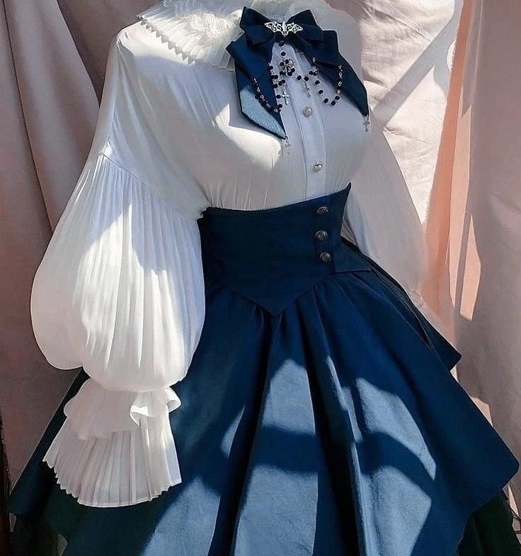 the image showcases a meticulously styled dress form, adorned in a captivating lolita fashion ensemble. the outfit boasts a pristine white blouse featuring exquisite ruffled sleeves and a delicate peter pan collar, accented with a charming black bow. the pièce de résistance is a navy blue skirt, cinched at the waist with a sleek corsetstyle belt and cascading gracefully to the floor. the ensemble exudes an aura of elegance and sophistication, reminiscent of victorianera aesthetics, while simultaneously embracing a touch of modern charm.