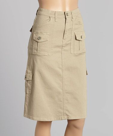 a woman is wearing a beige cargo skirt with pockets. the skirt is a casual style and can be worn for a variety of occasions.