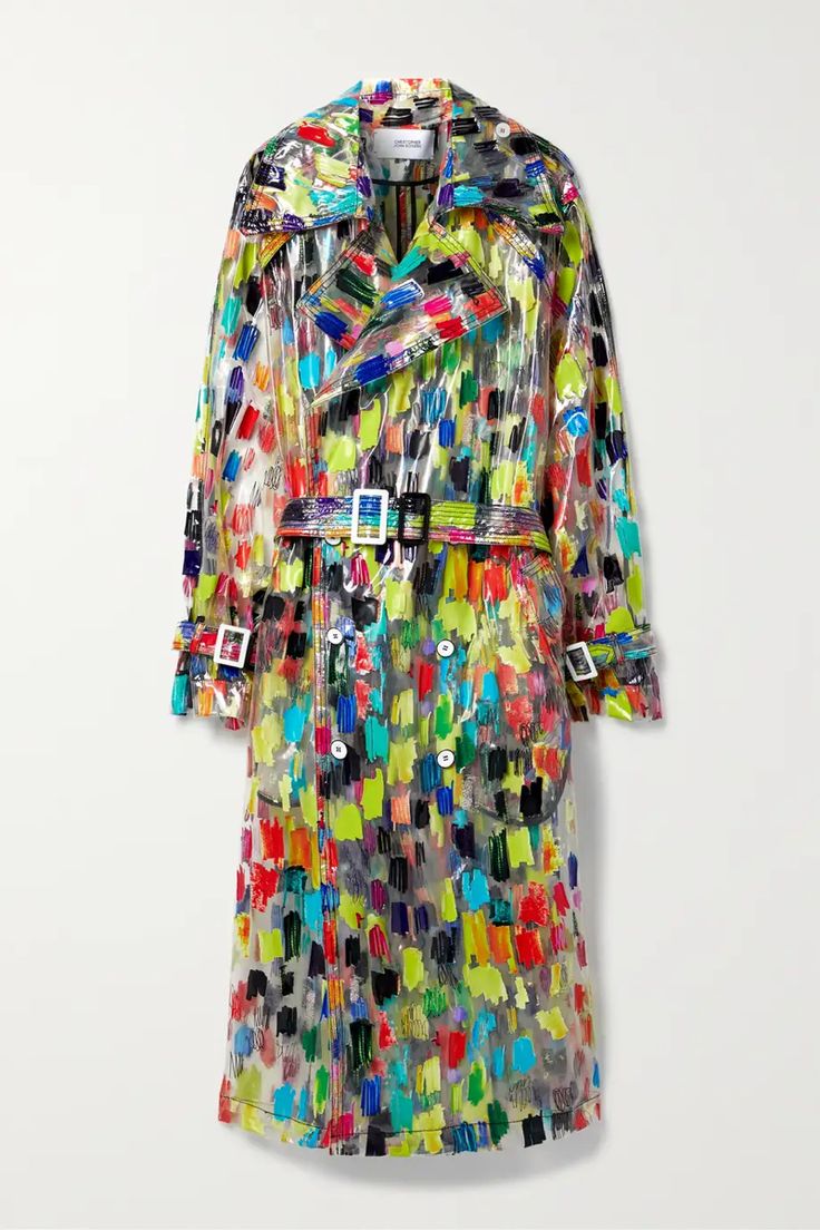 a colorful, transparent trench coat is displayed against a plain white background. the coat features an allover pattern of brushstrokes in various colors including red, green, blue, yellow, and black. it has a belted waist with buckles, buttons down the front, and traditional trench coat details. the transparent material allows the pattern to be seen through.