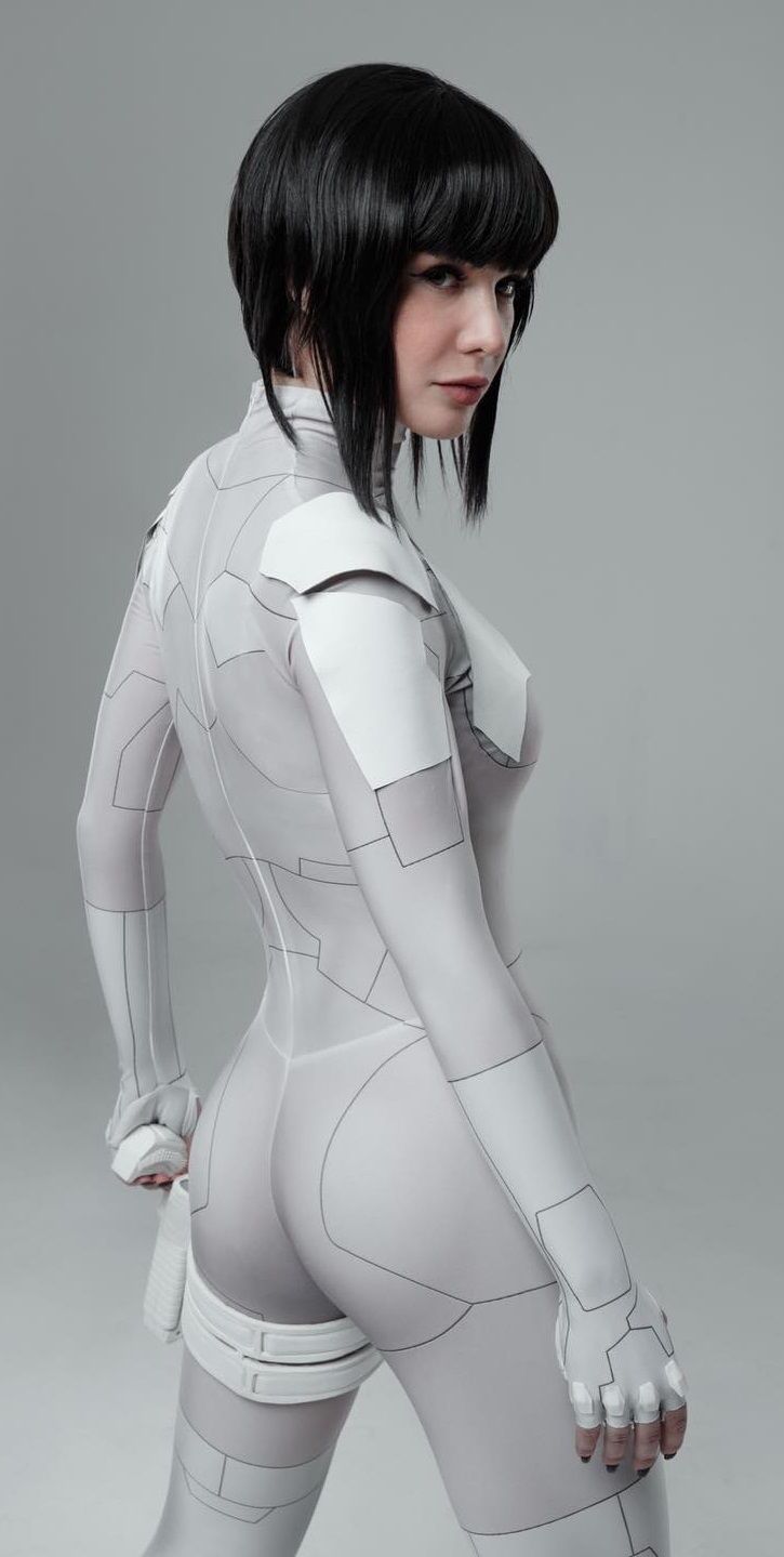a woman in a cyberpunk anime cosplay suit, poses against a white background,  the woman is wearing a white suit and gloves, looking at camera.