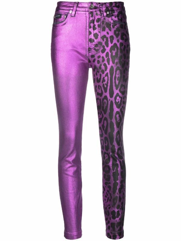 a pair of tightfitting, purple jeans. the left leg is a solid metallic purple color, while the right leg features a leopard print pattern in black.