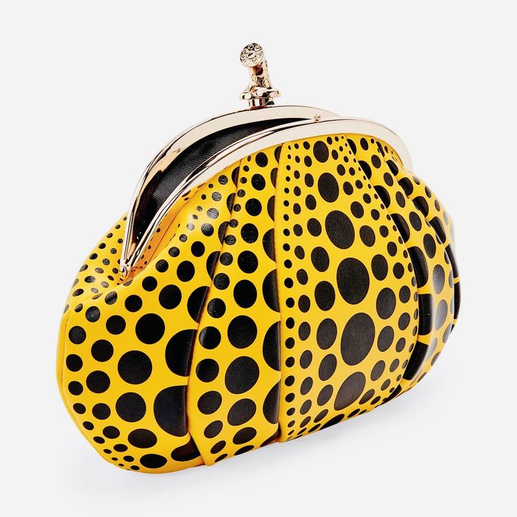 a yellow and black polka dot purse with a gold clasp is shown against a white background. the purse is shaped like a dumpling or pouch, with the polka dots varying in size. the clasp is metal and has a unique, decorative top.