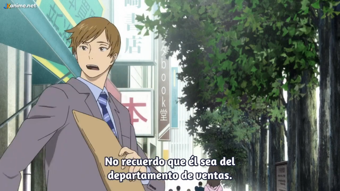 an anime screenshot of a young man in a grey suit, light blue shirt, and blue tie, holding a brown folder, looking surprised on a city sidewalk lined with trees.  there is japanese writing on signs in the background.```