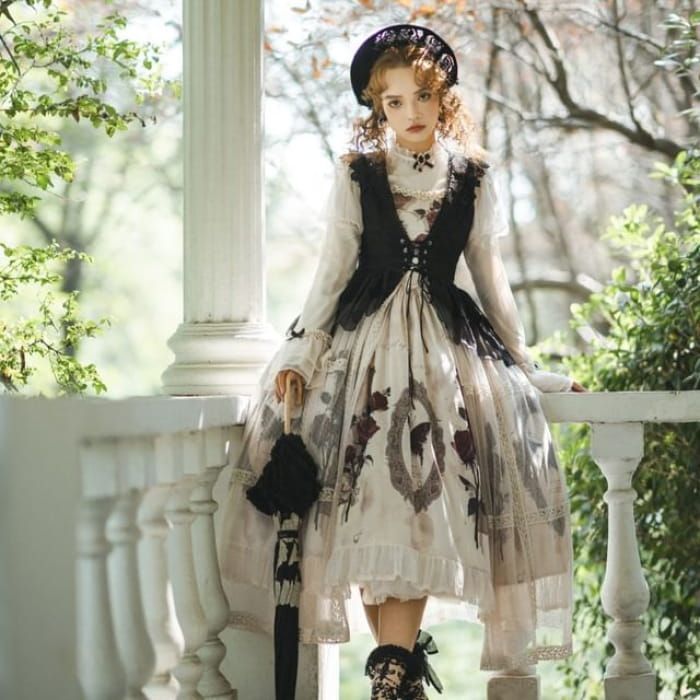 a woman in a vintageinspired dress and hat poses on a porch with a lacetrimmed umbrella. she is surrounded by greenery, suggesting a garden setting. her outfit features a black bodice with lace trim over a flowing cream skirt with a floral print. the overall aesthetic evokes a romantic and elegant mood.