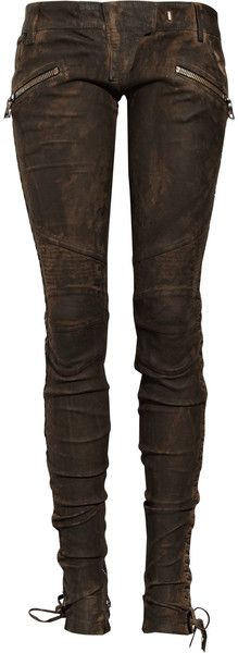 a pair of brown, distressed leather pants are displayed against a white background. the pants are skinny fit with zipper pockets at the top and laceup detailing at the bottom.