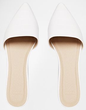 a pair of women's white pointedtoe slipon flats are shown against a white background.  the shoes are simple and minimalist in design, with a clean, pointed toe and a light beige insole visible at the bottom. they appear to be made of a smooth, possibly leatherlike material. the shoes are positioned so that the toes point upward.