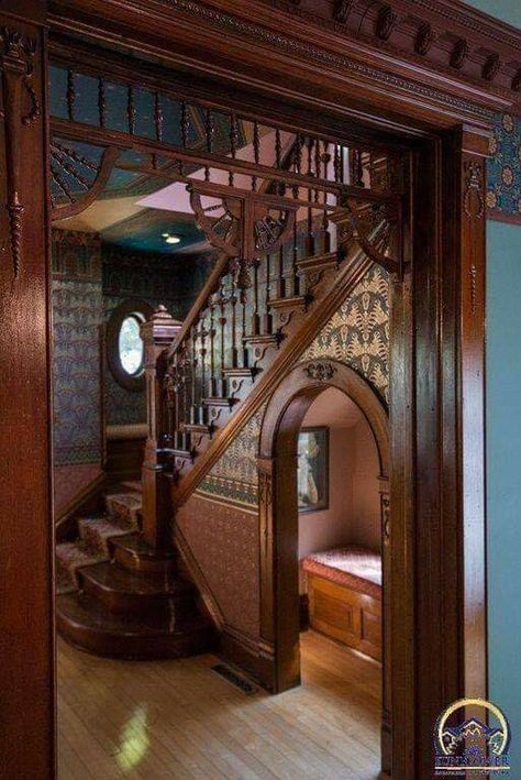 this is an image of a grand wooden staircase in a victorianera home. the intricate woodwork and detailing are typical of the era, and the warm wood tones create a welcoming atmosphere. a small bench is tucked under the stairs, inviting visitors to take a seat and admire the craftsmanship.