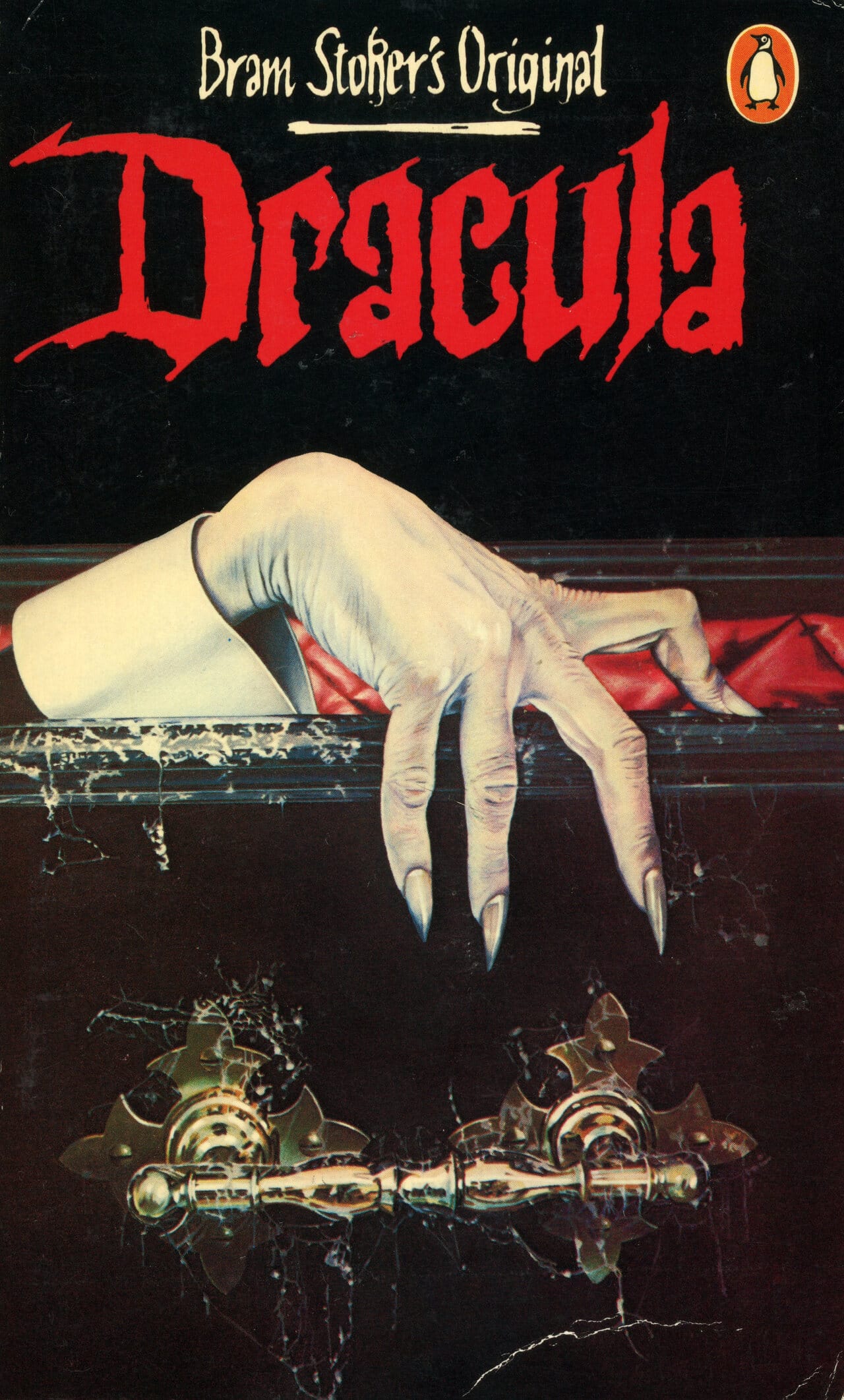 this is a book cover for a penguin books edition of bram stoker's dracula. the cover features a dramatic illustration of a pale hand with long, sharp fingernails emerging from a coffin. the title "dracula" is prominently displayed in bold, red lettering. the background is dark and moody, enhancing the overall gothic and horror atmosphere. the penguin logo is visible in the upper right corner. the style suggests a vintage book cover, likely from the 1970s or 1980s.  ornate gold door handles are partially visible at the bottom.