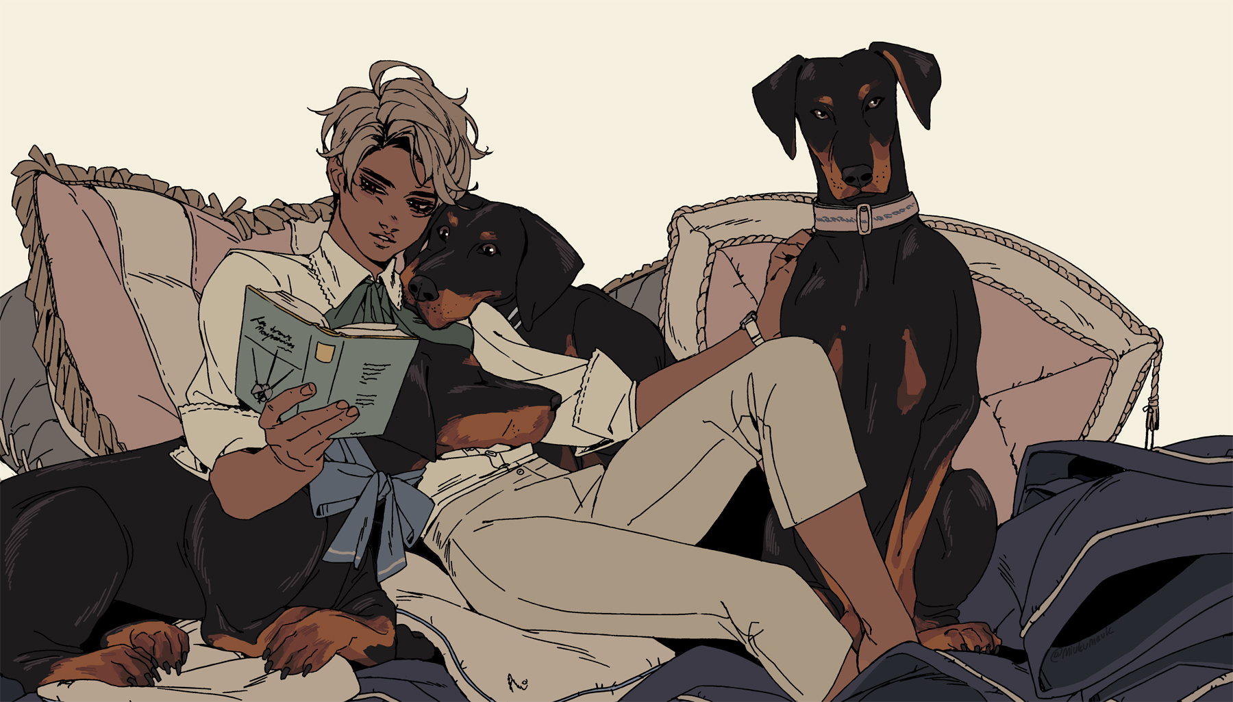 a man is sitting on a couch with two doberman dogs, reading a book.  he is comfortably nestled amongst pillows while the dogs relax at his feet.  the man is dressed in a white shirt, a tie, and white pants. the dogs are black and brown.