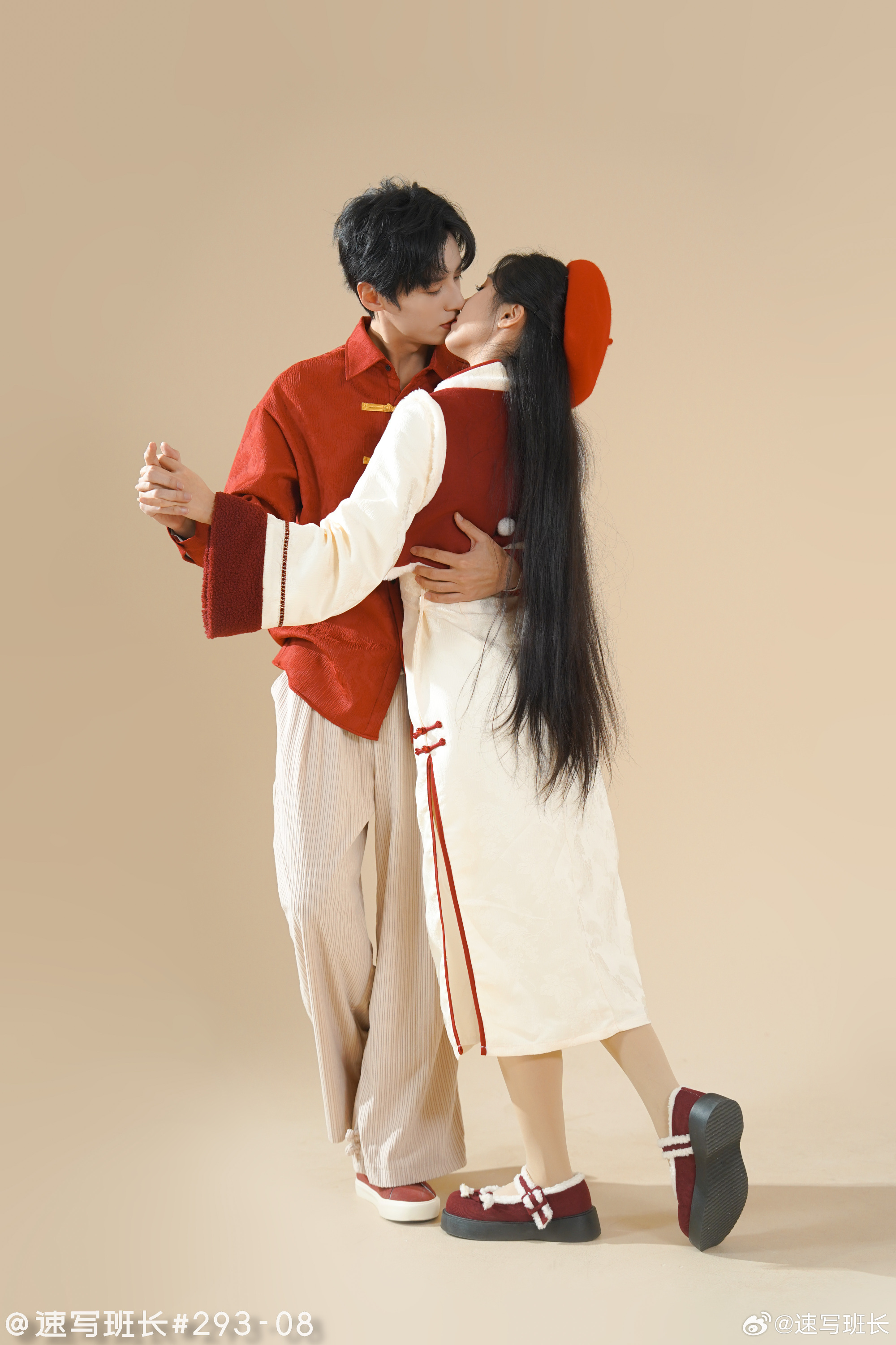 a young couple is locked in a romantic embrace, sharing a kiss. they are dressed in stylish, modernized traditional chinese clothing, with the man in red and white and the woman in white and red. the woman has long black hair and is wearing a red beret, while the man has short black hair. the background is a soft beige, highlighting the couple and their affectionate moment. the overall feel is one of love, happiness, and celebration, possibly in the context of a chinese new year celebration.