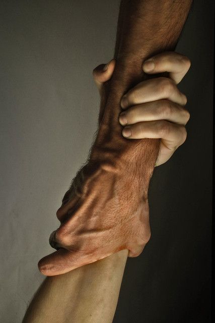 a closeup shot of a man's hand gripping another man's arm. the image is focused on the hand and arm, showing the strength and power of the grip. the texture of the skin and the visible veins add to the image's intensity. the image could be interpreted as a symbol of support, help, or even dominance.