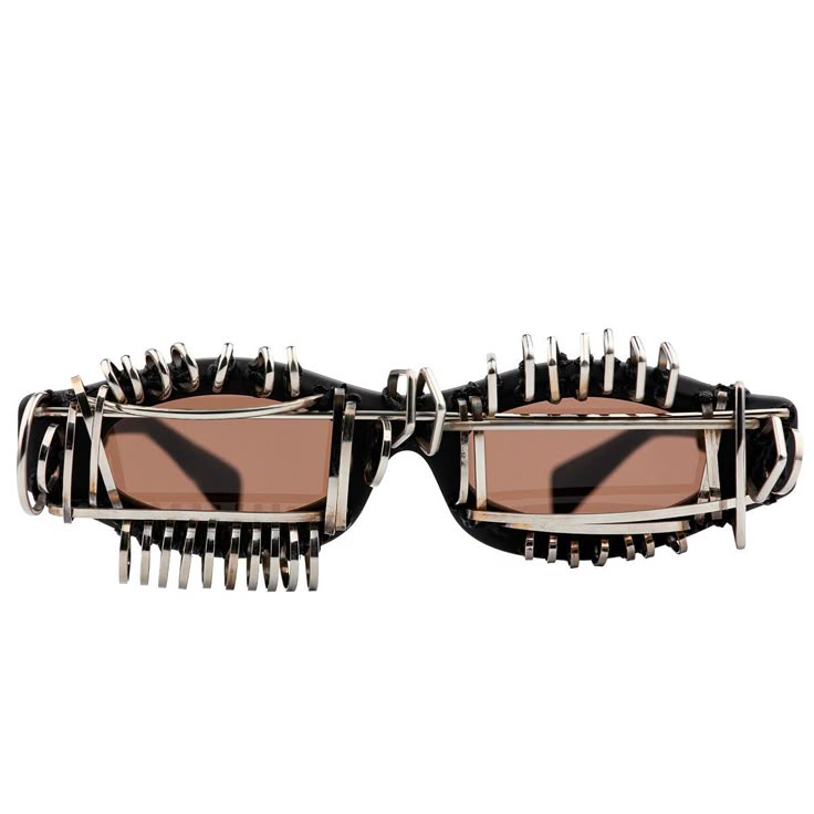 the image shows a pair of avantgarde sunglasses with a unique and unusual design. the frames are black and heavily adorned with silvercolored metal pieces, giving them a futuristic and somewhat industrial appearance. the lenses are a light brown color. the sunglasses are isolated on a white background.