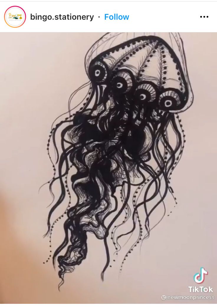 a black and white ink drawing of a jellyfish on white paper. the jellyfish is drawn in a zentangle style with intricate patterns and details.
