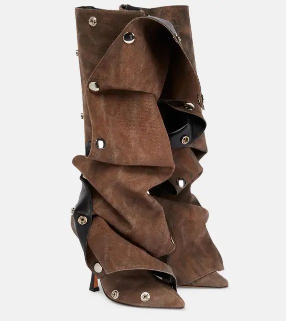 a pair of stylish, kneehigh brown suede boots with black accents and gold eyelets, showcasing a unique design with multiple folds and layers. the boots feature a high heel and a pointed toe, exuding a sophisticated and feminine appeal. the image is taken against a white background, allowing the details of the boots to stand out.