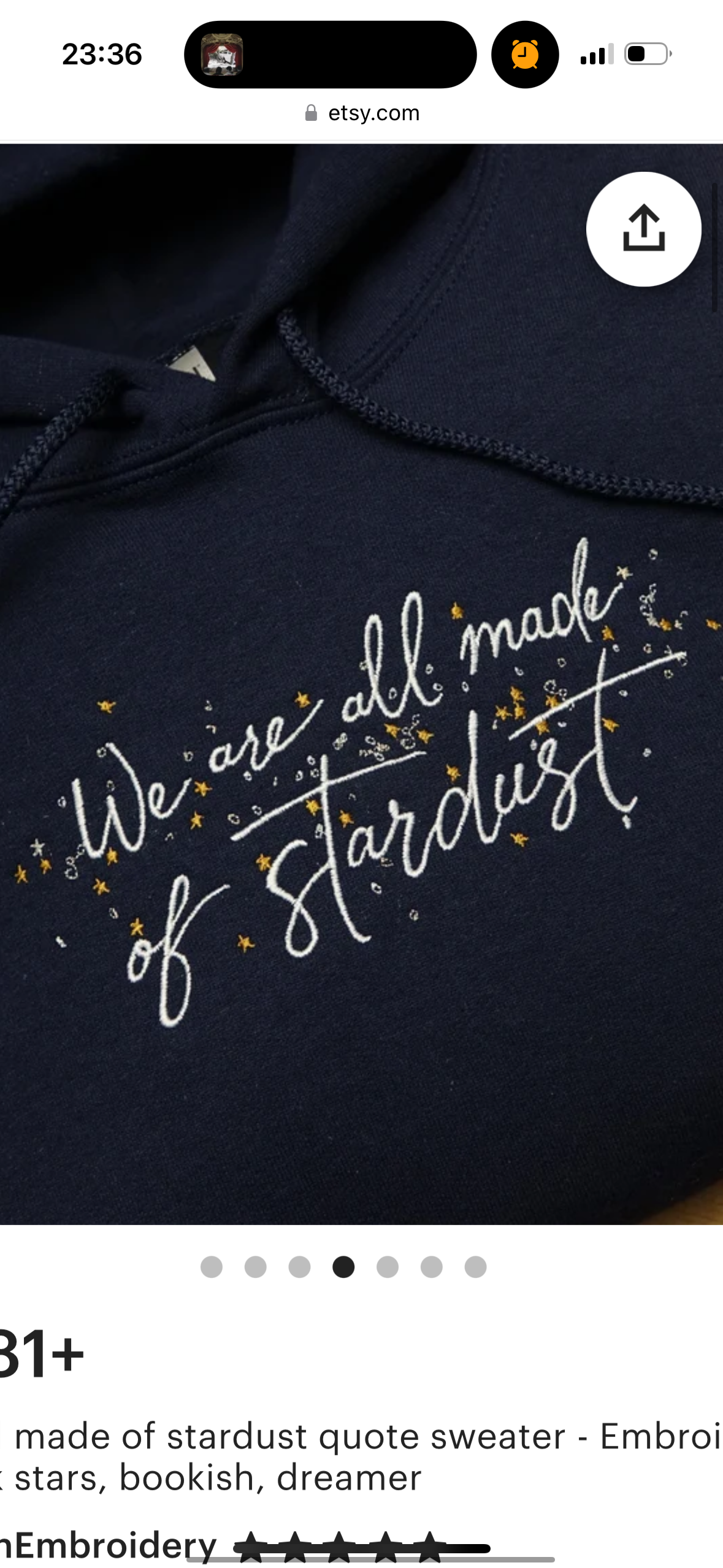 a navy blue hoodie with an embroidered quote "we are all made of stardust" in white thread with gold stars. the hoodie is shown on a product page with 31+ reviews, the title "made of stardust quote sweater  embroidered", and a fivestar rating for the embroidery. the hoodie is on a white background.