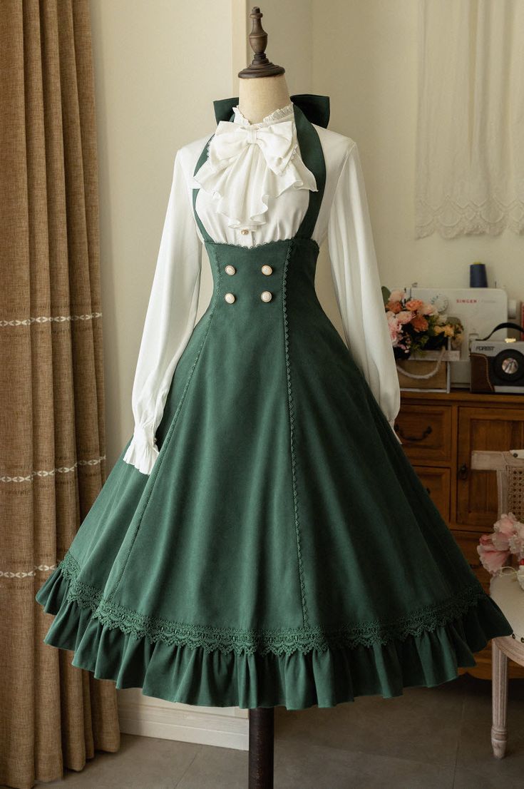 a green lolita fashion dress is displayed on a mannequin. the dress features a high waist, a long, flowing skirt with ruffles and lace trim, and a white blouse with a bow at the neck. the dress is shown in a welllit room with a vintage feel.
