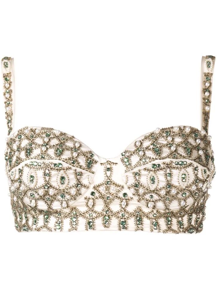 a white bra with intricate gold and green beading and embroidery. the bra is made of delicate fabric and has a feminine and glamorous look. the beading is very detailed and ornate, and the bra looks like it was handmade. the bra is an excellent example of luxury lingerie.