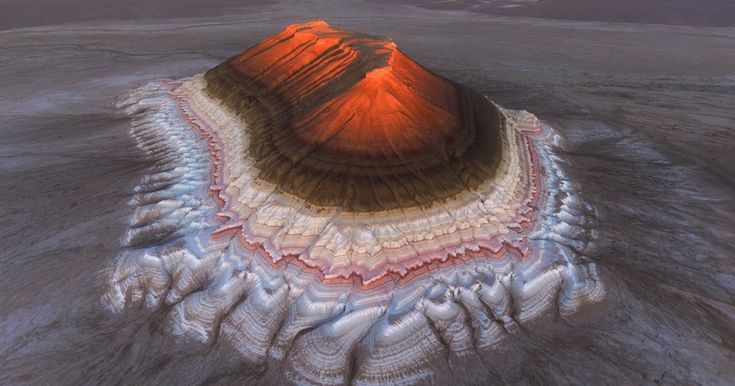 this image showcases a layered geological formation, likely a mountain or elevated landscape, resembling sedimentary rock layers. the scene appears to be set in a desertlike environment, possibly a martian landscape due to its unique geological features and coloration. the layers display distinct colors and textures, suggesting different sedimentary deposits accumulated over time. the erosion and weathering processes have shaped the formation, creating an intricate pattern of layers and textures.