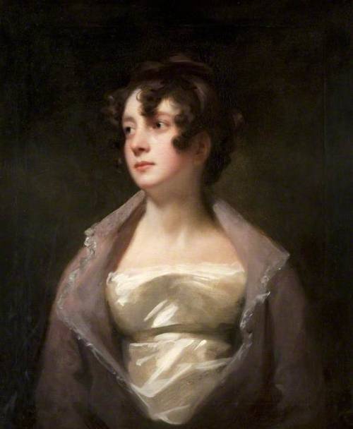 the image is a portrait of a young woman from the regency era, painted in oils on canvas. she is positioned slightly turned, offering a threequarter view of her face and body. the woman has dark curly hair styled in loose ringlets framing her face. she wears a white empirewaist gown with a delicate, sheer overlayer that drapes around her shoulders. her expression is serene and thoughtful, with her gaze directed slightly upward and to the viewer's left. the background is a dark, undefined space that helps to draw attention to the sitter's illuminated face and figure. the painting is characterized by soft lighting and a muted palette of browns, grays, and creams, creating a sense of quiet elegance and introspection.