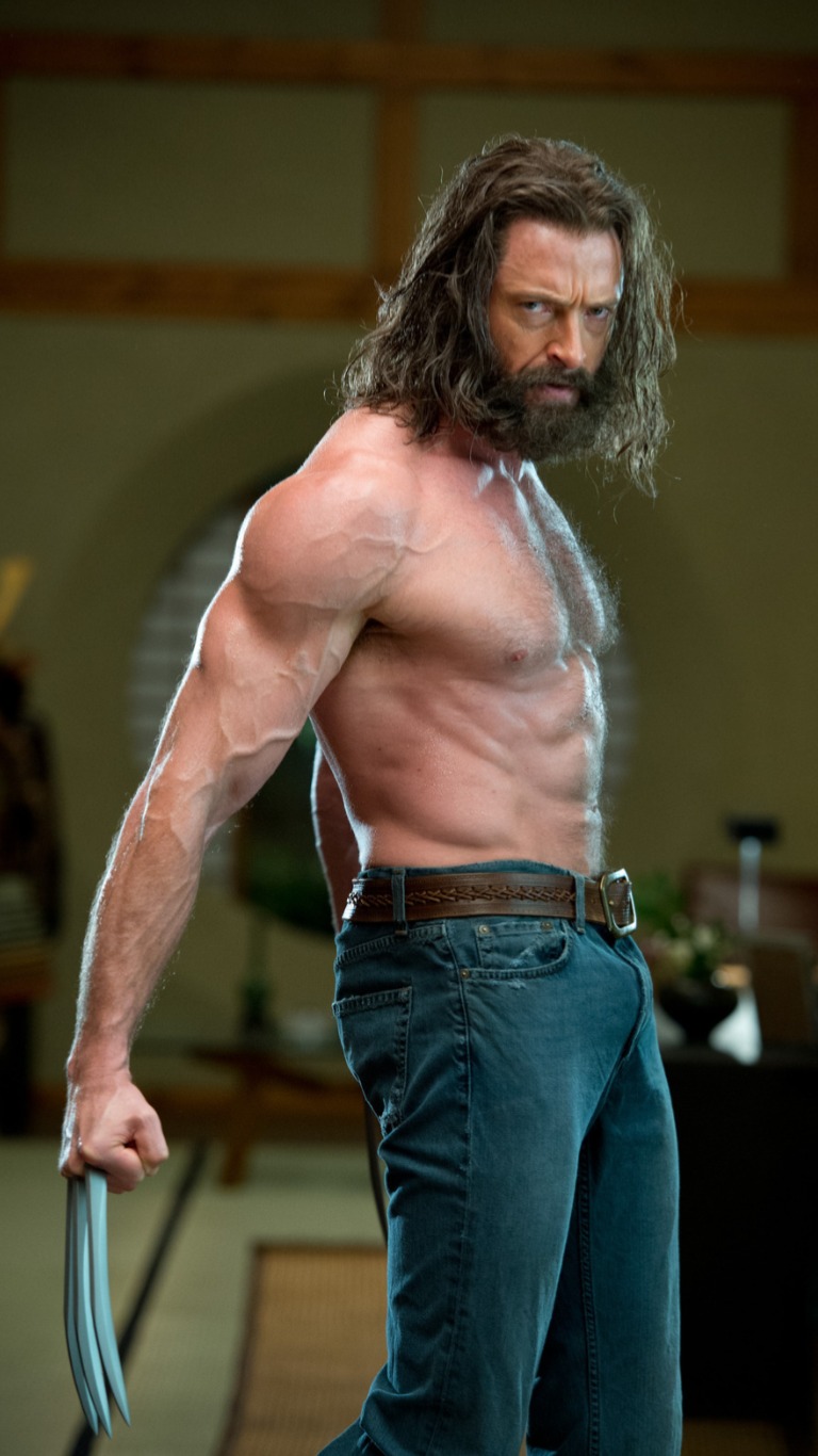 the image features hugh jackman as wolverine, a marvel superhero character. he is shirtless, showcasing his muscular physique, and wearing jeans. wolverine has a beard and long hair, and his signature metal claws are extended from his hand.