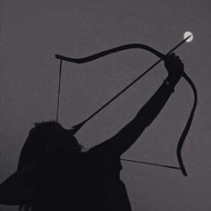a silhouette of a person holding a bow and arrow, aiming towards the sky. the background is dark, enhancing the contrast of the silhouette.