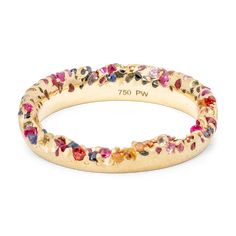a closeup image of a thin gold ring with a unique and beautiful design. the ring is decorated with a myriad of tiny, colorful gemstones that cover its surface. the ring appears to be a delicate and elegant piece of jewelry that would be perfect for a special occasion. the inscription "750 pw" is visible on the inner side of the ring.
