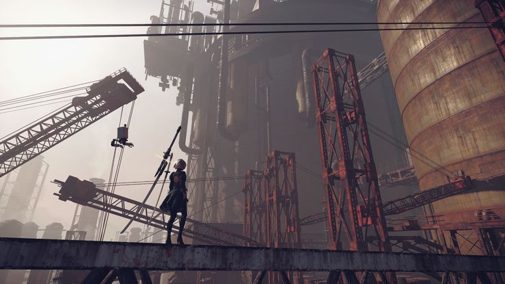 a still image from the video game nier: automata.  the image features 2b, a female android protagonist, standing on a metallic platform amidst a heavily industrialized, dilapidated cityscape.  the background shows massive rusty cranes, decaying industrial structures, and large cylindrical tanks.  the overall atmosphere is postapocalyptic and bleak, with a hazy, foggy environment creating a sense of desolation. 2b is holding a long swordlike weapon.