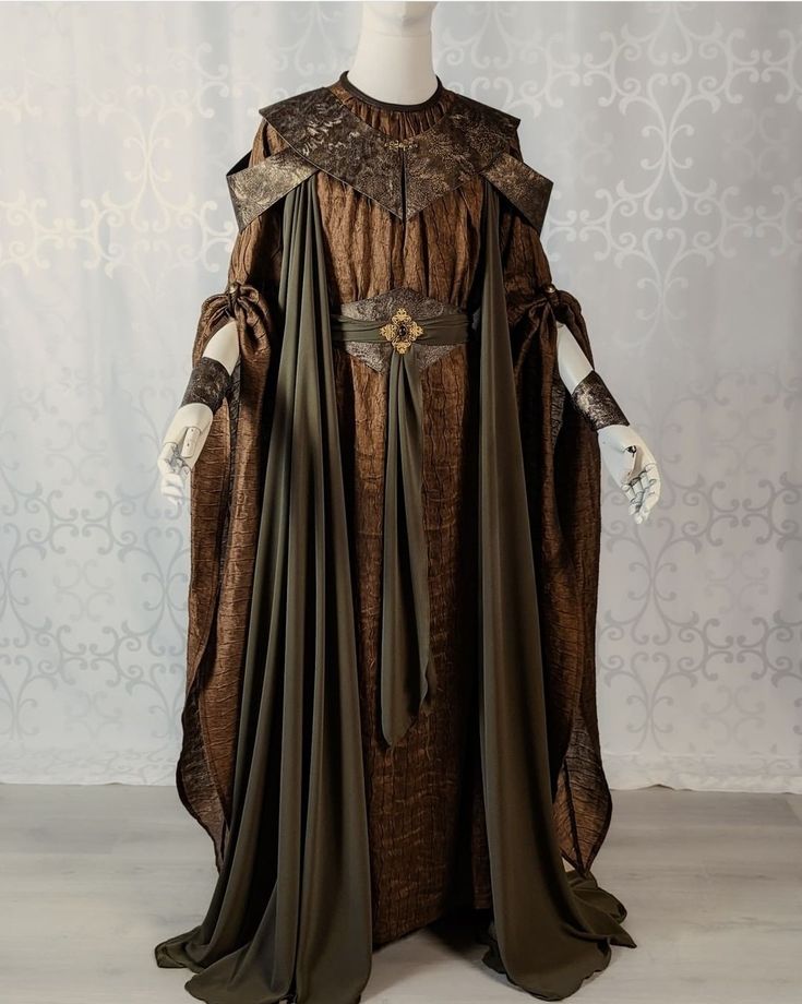 a fulllength brown and green dress with a long flowing robe and intricate details. the dress is made of a luxurious fabric and has a regal and majestic look. the outfit appears to be a historical or fantasyinspired costume, potentially for a ceremony, event, or wedding. the flowing fabric and elaborate design give it a grand and elegant air.