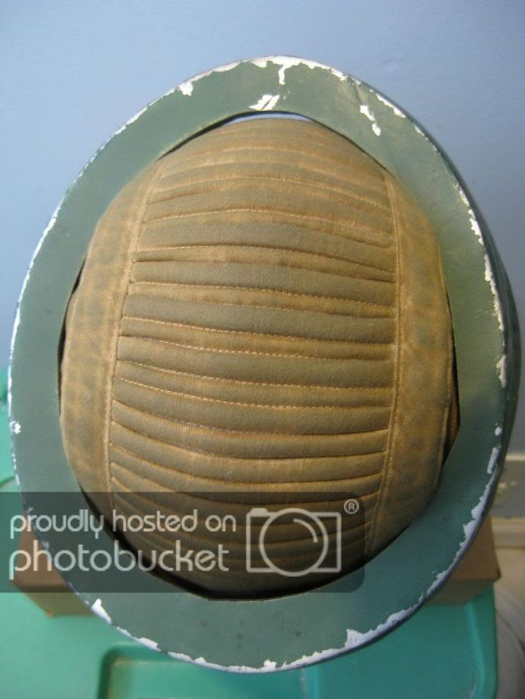 a vintage, green, padded helmet with a leather lining. the helmet is in good condition and is likely from world war ii.