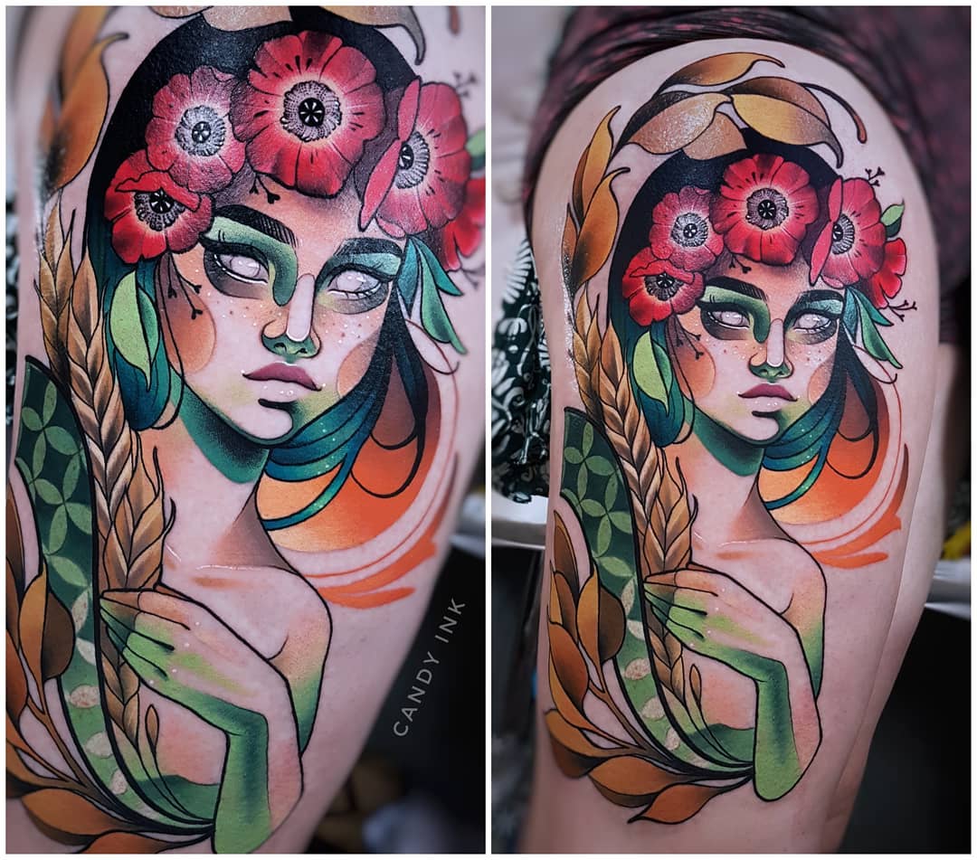 this is a twopanel image of a colorful tattoo of a woman on someone's upper thigh. the woman in the tattoo has green skin, white eyes, and is wearing a crown of red flowers. in the right panel, she is holding a stalk of wheat. the tattoo has leaves and other foliage surrounding the woman.