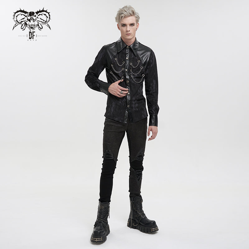 a fullbody studio shot of a male model showcasing a gothicinspired outfit. he is wearing a black longsleeved shirt with leather accents and chains across the chest, paired with black skinny jeans featuring decorative knee patches and black studded boots. the overall style is dark, edgy, and punkinfluenced. the model is posing against a clean white background.