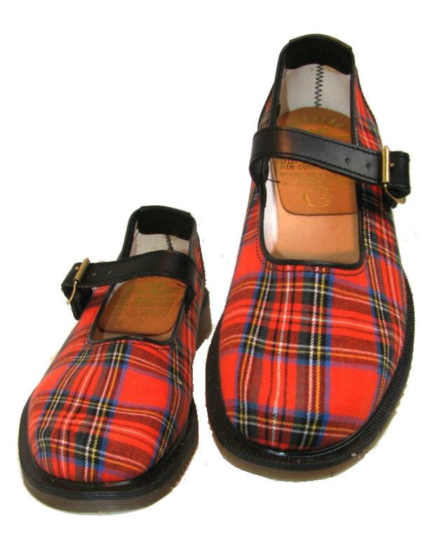 a pair of mary jane shoes with a red plaid pattern, black leather straps and buckle closures, sitting on a white background.