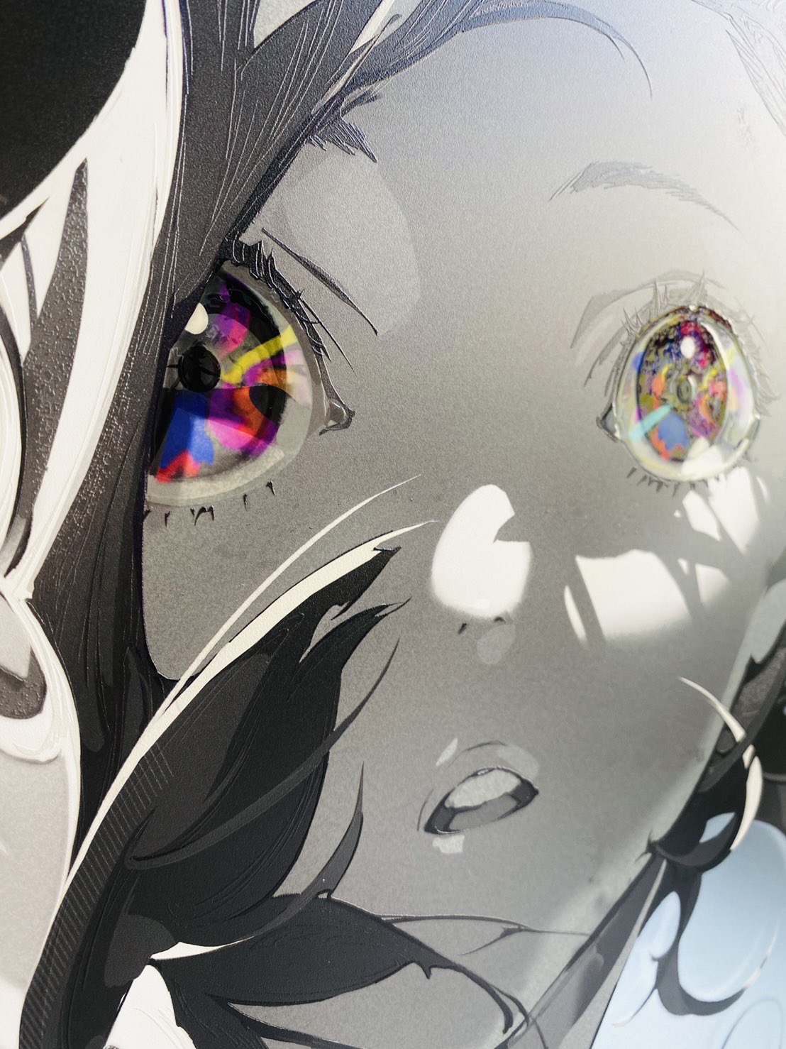 a closeup illustration of an anime girl's face. her eyes are the focal point of the image, with vibrant, multicolored patterns. the rest of the illustration is in black and white, creating a stark contrast and emphasizing the eyes. the girl has a surprised expression on her face.