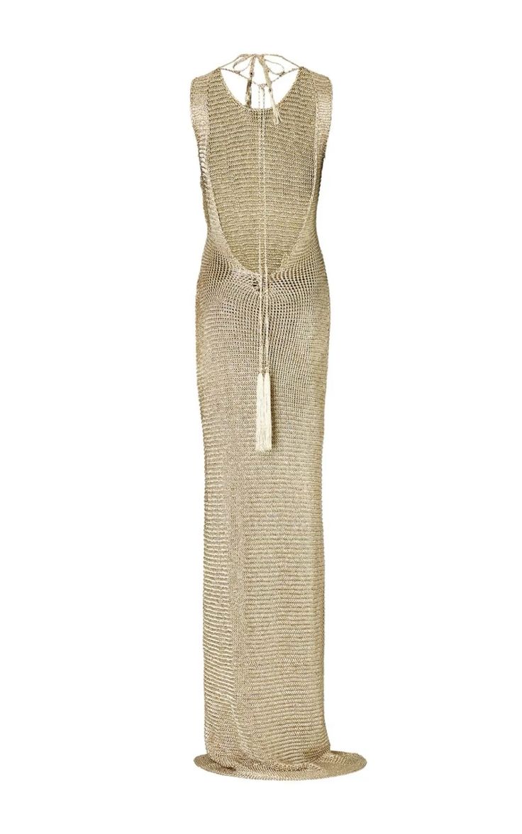 a full shot of a gold metallic knit maxi dress, sleeveless and backless with a tie back detail featuring a tassel. the dress is floorlength and has a relaxed fit. the fabric appears to be a fine knit or crochet.  the dress is shown on a white background, from behind.