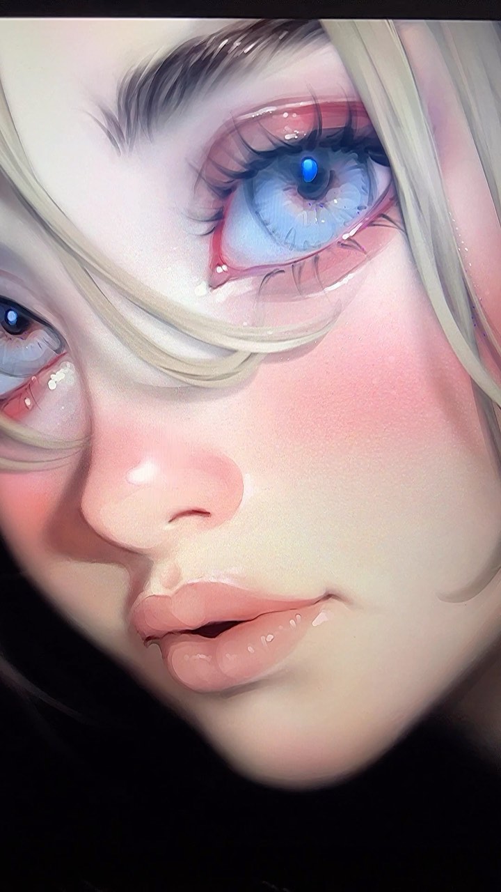 the image is a closeup digital painting or illustration of a young animestyle girl's face.  her features are soft and delicate, with large, expressive blue eyes that appear glossy and shiny.  her blonde hair partially obscures her face.  she has pink cheeks and full lips, and her skin has a soft, almost luminous quality. the overall style is dreamy and ethereal, with a focus on soft, subtle colors and a painterly technique. the image evokes a feeling of innocence and beauty.