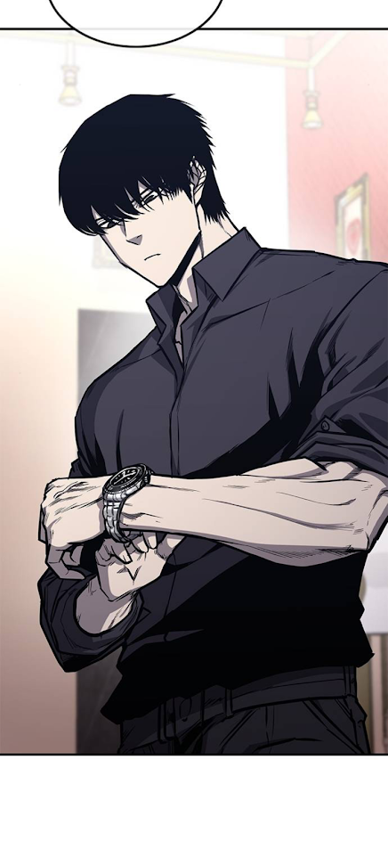 a man with black hair and a black shirt is looking down at his watch, his expression is serious. he's standing indoors, and the background is dark. the image is from a manga or anime comic book.