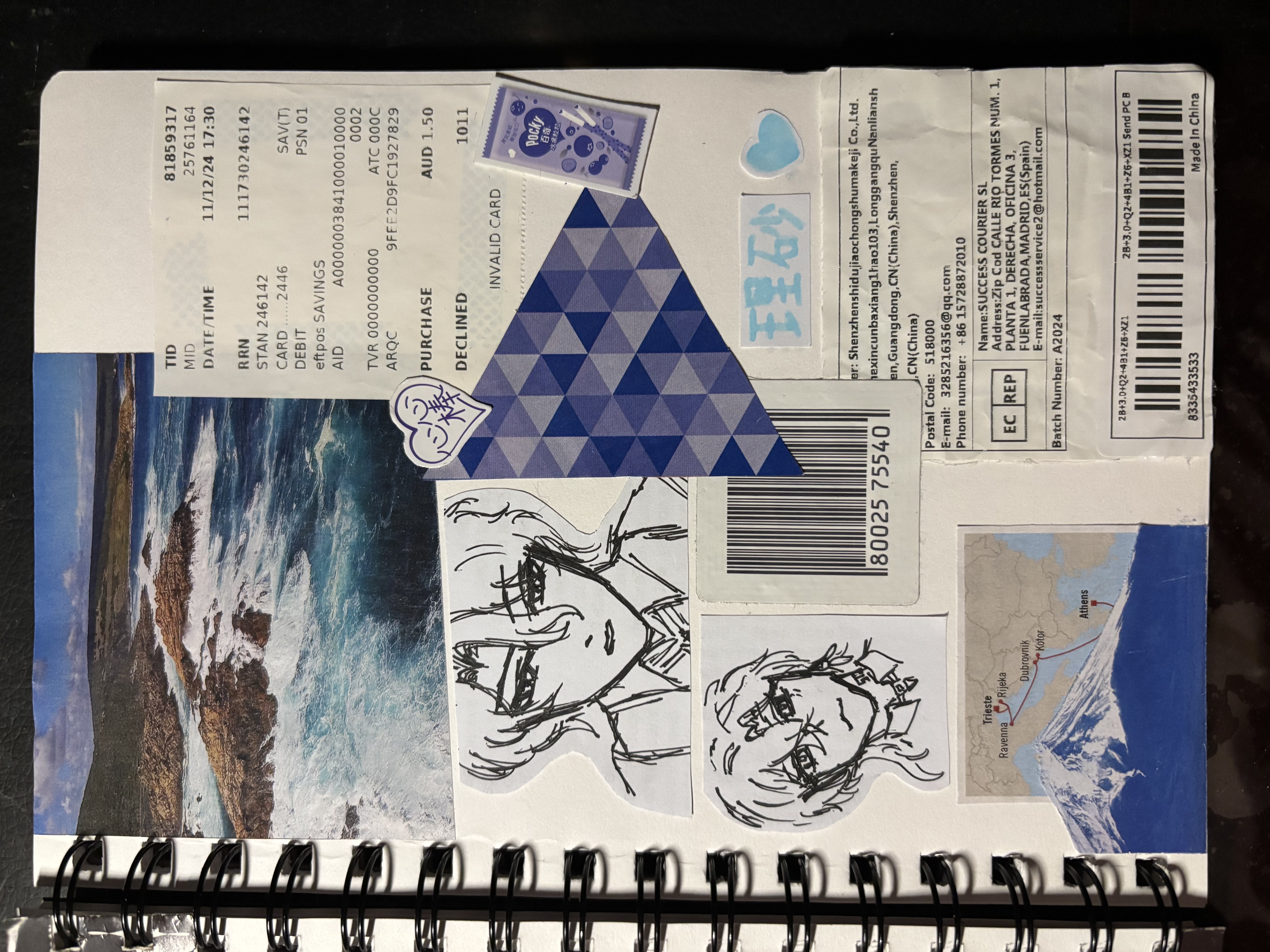 a spiral notebook page filled with collage elements including anime character drawings, a scenic ocean view image, a declined receipt, a barcode, package label, various stickers including a heart and geometric shapes, and a mountain drawing with a map.