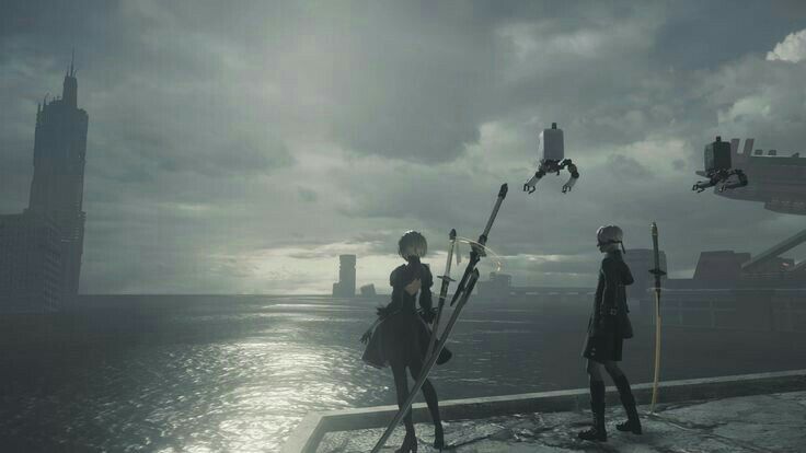 the image is a screenshot from the video game nier: automata.  it depicts two of the main characters, 2b and a2, standing on a waterfront overlooking a postapocalyptic cityscape. both characters are armed with katanas.  in the background, several flying robotic machines are visible, adding to the game's dystopian setting. the overall atmosphere is dark and gloomy, with a grey sky and a somber color palette. the scene suggests a moment of contemplation or perhaps anticipation before a confrontation.  the highquality graphics are typical of the game's visual style.