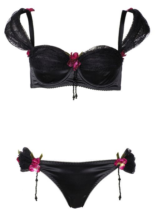 the image showcases a black lingerie set, featuring a bra and panty. the bra is adorned with lace and floral accents, and it has beaded embellishments hanging from the center. the panty also has similar floral accents and beaded embellishments on the sides.