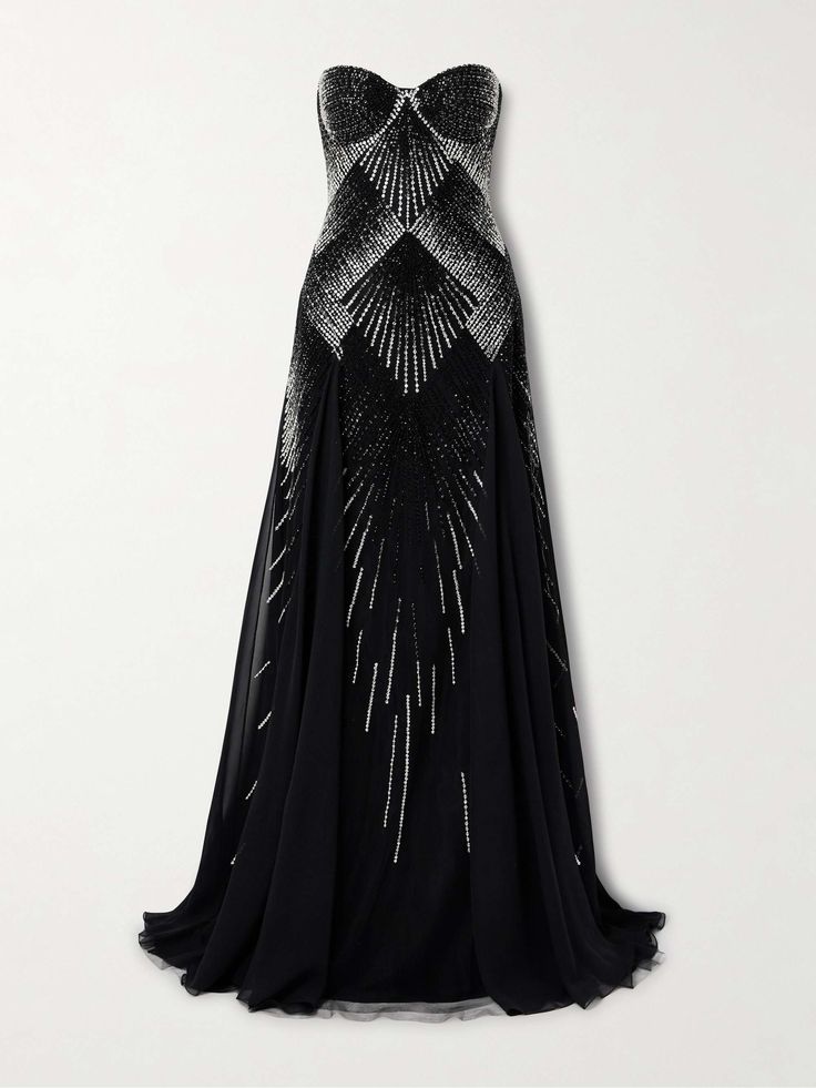 a black strapless gown with a fitted bodice and flowing skirt. the bodice is heavily embellished with sequins and beads in a geometric design. the skirt is made of a soft, sheer fabric that flows beautifully. the dress is perfect for a formal event, such as a wedding, prom, or award show.