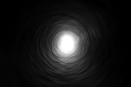 a black and white photo of a spiral tunnel with a light at the end. the tunnel is dark and the light is bright, creating a stark contrast. the photo could be interpreted as a symbol of hope or a journey towards something unknown.